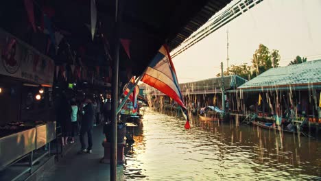 Bandera-De-Tailandia-Ondeando-Bajo-La-Lluvia,-Una-Noche-En-El-Mercado-Flotante-Damnoen-Saduak-De-Bangkok,-Cámara-Lenta,-4k-Uhd-60-Fps-En-Cámara-Lenta