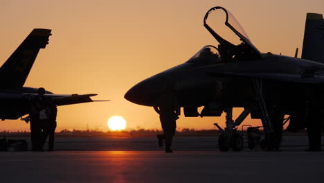 La-Silueta-De-Un-Oficial-Naval-Corre-Frente-A-Un-ángel-Azul-En-La-Pista-Mientras-Los-Aviones-Se-Preparan-Para-Una-Rutina-De-Exhibición-Aérea-Al-Amanecer-Temprano-En-Key-West.