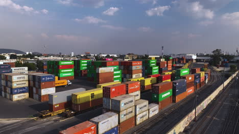 Vista-Aérea-Elevándose-Sobre-Cajas-De-Contenedores-En-Una-Estación-De-Tren,-Día-Soleado-En-México