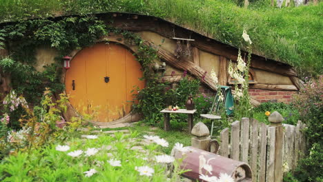 Pintoresco-Agujero-Hobbit-Situado-En-El-Set-De-La-Película-Hobbiton-Con-Hermosas-Flores-Blancas-Que-Adornan-El-Frente-De-La-Casa.