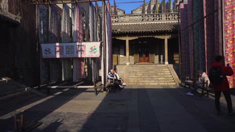 Traditional-looms-hanging-to-dry-in-a-Gubei-patio-while-people-admire-their-art