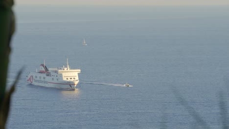 Ferry-ship-travelling-on-open-water-in-Mediterranean-Sea-heading-into-Harbor,-in-Barcelona,-Spain-on-warm-sunset-afternoon