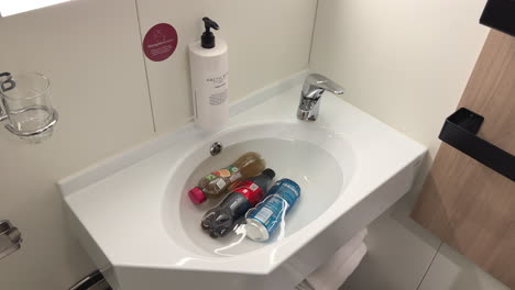 Cooling-beverages-and-drinks-in-a-sink-on-a-ferry,-static-shot