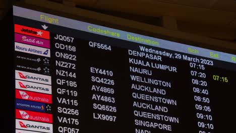 Airlines-departure-flight-schedules-displayed-on-the-billboard-at-the-International-Airport-of-Australia,-handheld-motion-close-up-shot