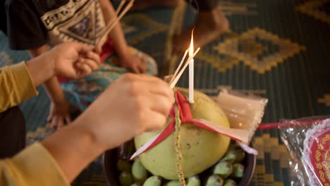 Asian-Woman-Lights-Incense-Spirit-House,-Place-Of-Worship-Near-The-Temple-In-Cambodia