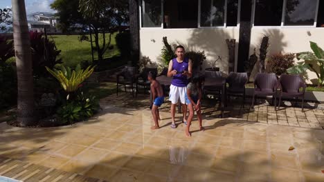 A-rearward-drone-shot-of-two-kids-jumping-into-the-pool