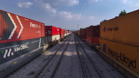 Vista-Aérea-Volando-Bajo-En-Medio-De-Contenedores-De-Tren,-Tarde-Soleada-En-México