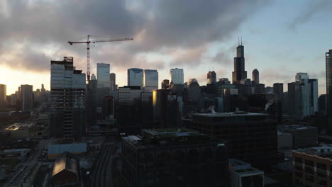 Vista-Aérea-Ascendente-De-Los-Edificios-En-El-Centro-De-Chicago-Desde-El-Distrito-Del-Río-Fulton,-Durante-El-Amanecer.