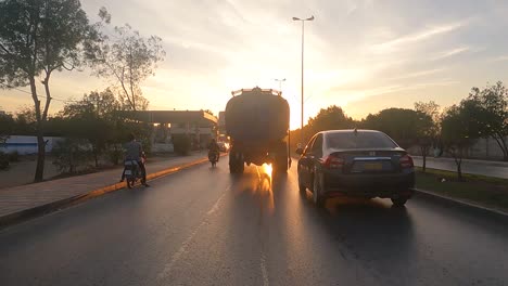 Karachi,-Pakistán:-Paseo-En-Automóvil-En-Una-Noche-Ajetreada-En-La-Ciudad-De-Karachi,-Pakistán,-Con-La-Puesta-De-Sol-Al-Fondo