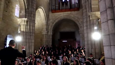 Eine-Nach-Unten-Geneigte-Aufnahme-Aus-Einem-Rosettenfenster-Und-Einer-Orgel-Zeigt-Einen-Orchesterdirektor,-Der-In-Der-Kathedrale-Von-Porto-Einen-Thunfisch-Dirigiert