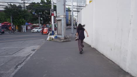 Mujer-Corre-A-Lo-Largo-De-La-Acera-Mirando-Hacia-Atrás-Con-Miedo-Carreras-Alrededor-De-La-Curva-De-La-Carretera