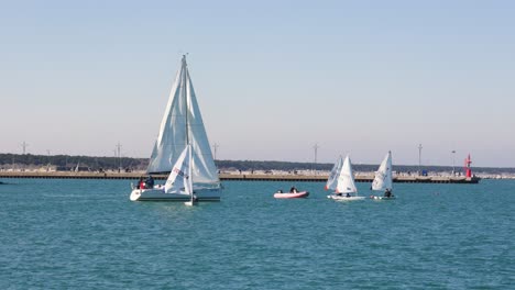 Crew-of-dinghy-small-sailboat-practice-watersport-on-blue-sea-on-a-sunny-and-windy-day