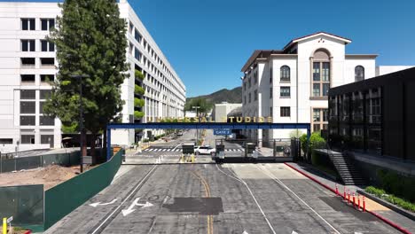 Universal-Studios-lot-security-gate-empty-entrance,-aerial-view-low-angle-approaching