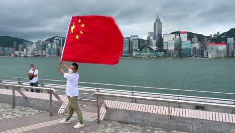 Un-Hombre-Posa-Con-La-Bandera-China-En-El-Puerto-De-Victoria-Durante-El-25º-Aniversario-Del-Establecimiento-De-La-Región-Administrativa-Especial-De-Hong-Kong-De-La-República-Popular-China.