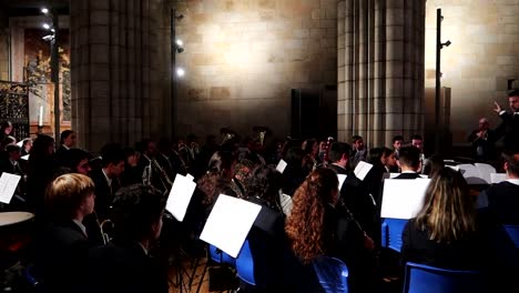 Beim-Schwenken-Nach-Rechts-Sieht-Man-Einen-Orchesterdirektor,-Der-In-Einer-Kathedrale-Eine-Thunfischkapelle-Mit-Einem-Taktstock-Dirigiert