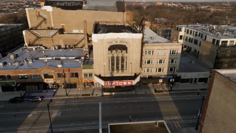 Aerial-view-of-birds-flying-around-the-Uptown-Theatre,-golden-hour-in-Chicago,-USA