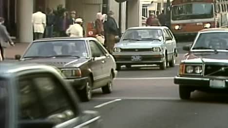 1983-Gente-Ocupada-Caminando-Por-El-Centro-Con-El-Tráfico-De-La-Ciudad