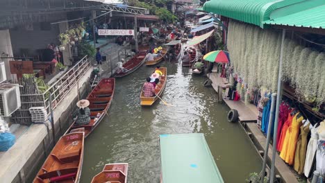 Los-Turistas-Disfrutan-Del-Paseo-En-Barco-En-El-Mercado-Flotante-Damnoen-Saduak,-La-Atmósfera-Vibrante-Y-El-Colorido-Paisaje-En-La-Provincia-De-Ratchaburi,-Al-Suroeste-De-Bangkok,-Tailandia.