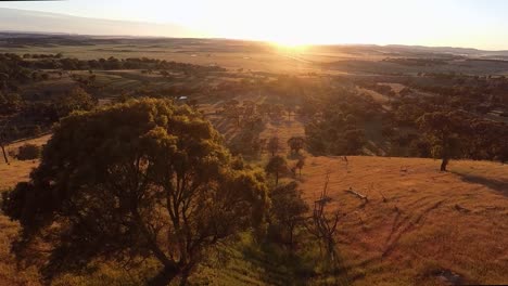 Vuela-Sobre-El-Paisaje-Australiano-Mientras-Sale-El-Sol-Al-Fondo.