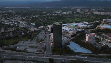 Vista-Aérea-Alrededor-De-La-Torre-Comcast-Nbc-Universal-City-Plaza,-Puesta-De-Sol-En-Los-Angeles,-Estados-Unidos