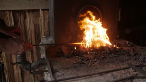 Un-Recreador-De-Herrero-Da-Vida-A-La-Historia-Al-Retratar-A-Un-Herrero-Tradicional,-Mostrando-El-Arte-Y-El-Comercio-Del-Trabajo-Del-Metal-Con-Herramientas-Y-Métodos-Auténticos.