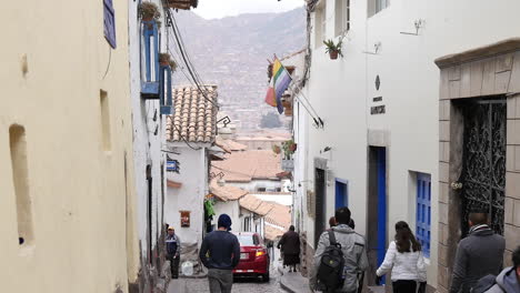 Caucasian-male-walking-past-group-of-people-down-alleyway-in-peru