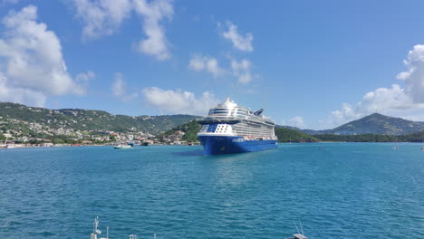 Modern-cruise-ship-approaching-slowly-in-Caribbean-island,-preparing-to-dock-ship-on-pier-|-beautiful-island-background-with-cruise-ship-commercial-video-background-in-4K