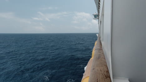 The-side-of-a-cruise-ship-as-it-sails-in-blue-water