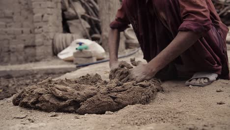 Man-deftly-mixes-clay-for-pottery-close-up