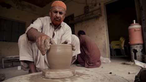 Un-Anciano-Experimentado-Elaborando-Una-Vasija-De-Barro-En-Un-Torno-De-Alfarero.