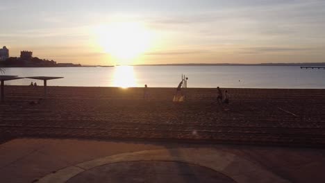 Ariel-Drohnenverfolgung-Kreist-Von-Rechts-Nach-Links-Am-Strand-über-Den-Leuten,-Die-Volleyball-Spielen