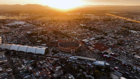 Drone-shot-orbiting-the-Plaza-de-Toros,-bullfight-arena,-sunny-evening-in-Aguascalientes,-Mexico