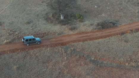 Luxurious-G-class-Mercedes-Benz-car-driving-on-an-unpaved-road-in-the-countryside