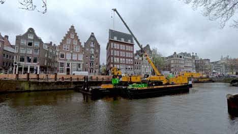 Blick-Auf-Den-Schwimmenden-Lastkahnkran-Auf-Dem-Amsterdamer-Kanal-Für-Kanalverstärkungsarbeiten-An-Bewölkten-Tagen