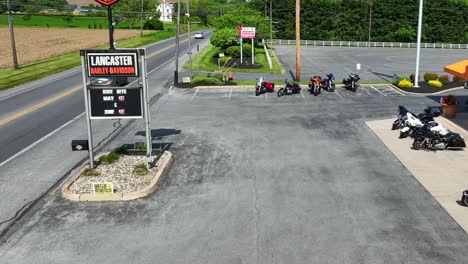 Redneck-man-flicking-off-drone-while-riding-Harley-Davidson-motorcycle-at-dealer