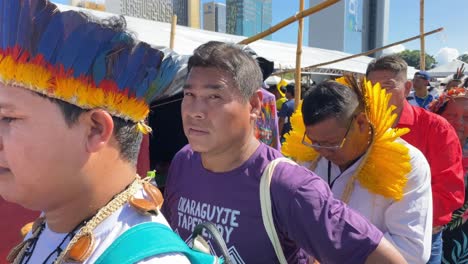 Indigenous-Amazonian-men-and-women-wearing-traditional-feather-hats-at-a-marketplace-in-Brazil