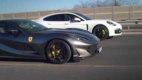 Black-Ferrari-racing-a-Porsche-on-a-highway