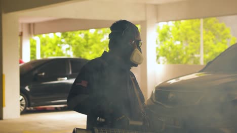 Close-up-of-a-fogging-worker-carrying-the-insecticides-sprayer-machine-in-a-car-park-area