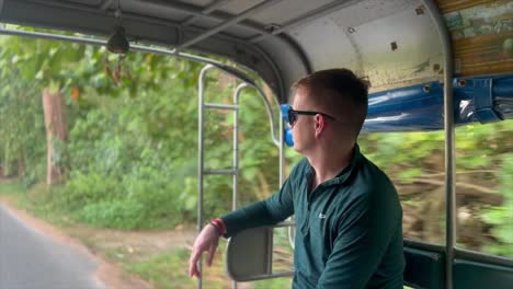 tourist-riding-in-the-back-of-a-tuktuk-taxi-watching-the-world-go-by