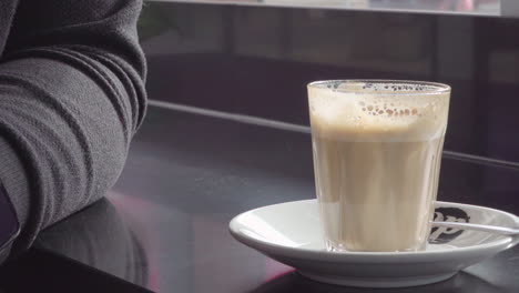 close-up-view-capturing-the-motion-of-lifting-the-coffee-from-the-table