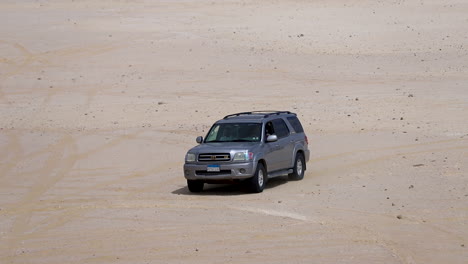 Camp-car-walking-on-the-sand-under-the-hot-sky-in-the-desert