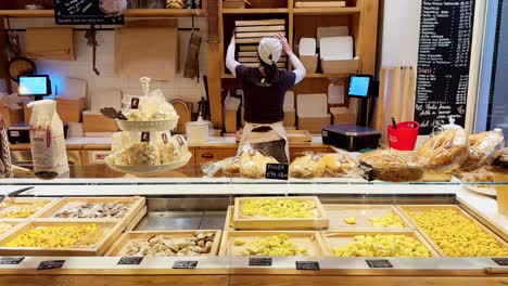 Woman-worker-ordering-items-in-a-fresh-pasta-shop-in-Italy