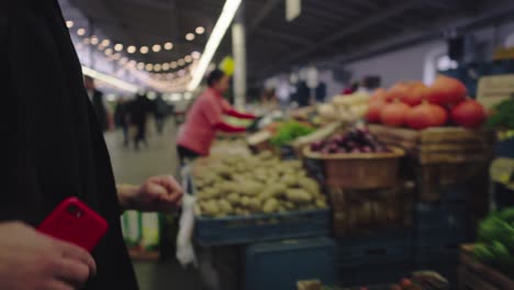 Eine-Frau-Betrachtet-Eine-Gurke-Auf-Einem-örtlichen-Obst--Und-Gemüsemarkt