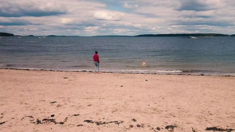 Mujeres-Jugando-Con-Un-Perro-Golden-Retriever-En-La-Playa-East-End-De-Portland,-Maine