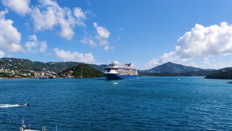 En-Primer-Plano,-Un-Magnífico-Crucero-Ocupa-Un-Lugar-Central,-Mientras-Que-Al-Fondo,-Una-Impresionante-Isla-Caribeña-Revela-Su-Esplendor-Natural.