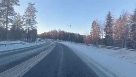 Das-Auto-Glitt-über-Die-Winterstraße,-An-Deren-Rändern-Kiefern-Standen,-Deren-Äste-Mit-Schnee-Geschmückt-Waren-Und-Ein-Malerisches-Winterwunderland-Schufen