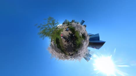 Tiny-Planet-Hyperlapse-Aufnahme-Von-Menschen,-Die-Auf-Einem-Weg-Gehen,-Der-Durch-Den-Blühenden-Japanischen-Kirschbaum-Sakura-Park-In-Vilnius-Führt