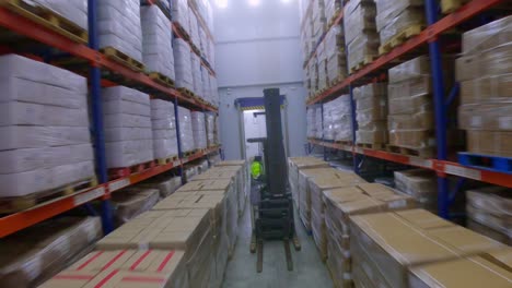 Fpv-flight-following-worker-forklift-transporting-shipment-in-FROZEN-FOOD-WAREHOUSE