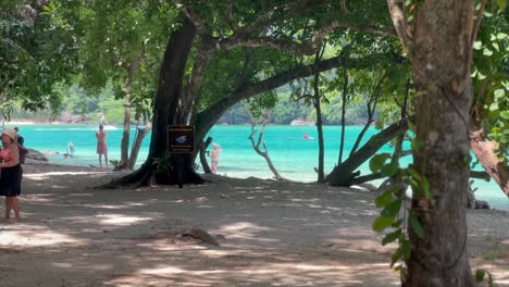 Tourists-exploring-idyllic-tropical-island-beach-in-paradise