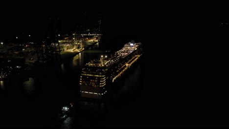 Cruise-ship-MSC-MUSICA-leaving-port-of-Montevideo-during-night-time-assisted-by-tug-boats